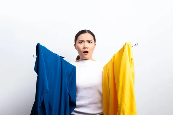 Γυναίκα αισθάνεται σύγχυση στην επιλογή μπλούζα απομονώνονται πάνω από το λευκό backgr — Φωτογραφία Αρχείου