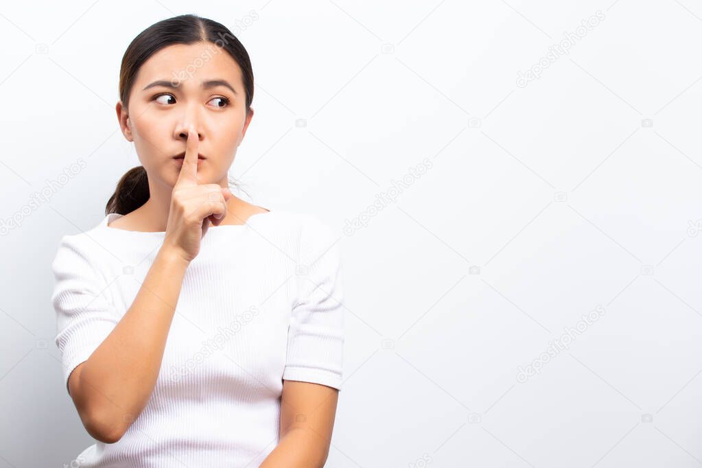 Woman making hush gesture standing isolated over white backgroun