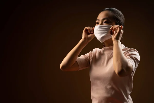 亚洲妇女戴着防护面罩 以抵御从米黄色背景分离出来的病毒和疾病 Covid 19概念 低调点 — 图库照片