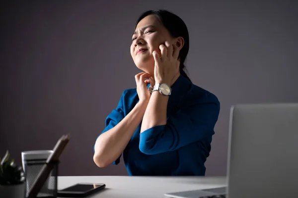 Mavi Tişörtlü Asyalı Bir Kadın Dizüstü Bilgisayarla Çalışırken Cildini Kaşındıran — Stok fotoğraf