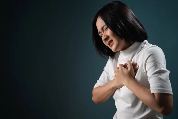 Asian woman was sick with chest pain and standing isolated over blue  background. Health care concepts. | Stock Images Page | Everypixel