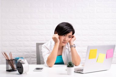 Ofisteki sıkıcı kadın dizüstü bilgisayarla çalışıyor.