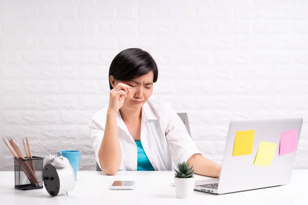 Sad woman sitting at home office working using computer laptop