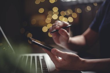 Akıllı telefondaki akıllı kalem daktilosunu kullanarak bilgisayarın parlak arka planında arama yapmak için ellerin yakın çekimini yap. Alçak tuş.