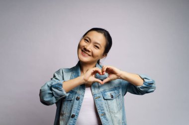 Aşık bir kadın beyaz arka planda izole edilmiş aşk sembolü yapıyor..