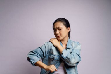 Asyalı kadın vücuduna dokunduğu için hastaydı ve beyaz arka planda tek başına duruyordu..