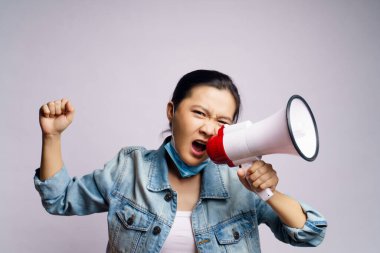 Beyaz arka planda izole edilmiş megafonla bağıran koruyucu yüz maskesi takan Asyalı kadın..