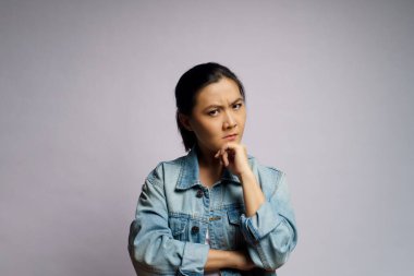 Asyalı kadın sorun düşünüyor, endişeli ve kafası karışık duygular arka planda izole edilmiş..