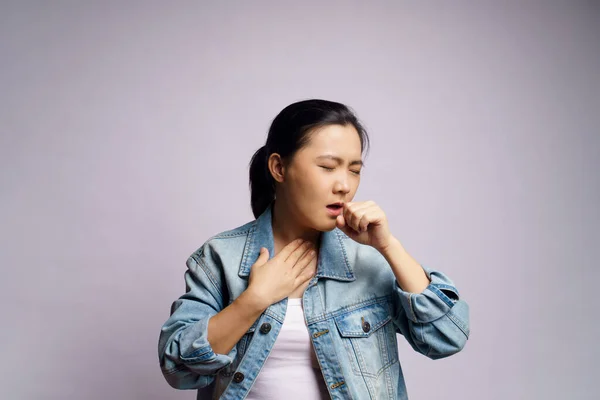 Asian woman was sick with fever, coughing sneezing and standing isolated on white background.