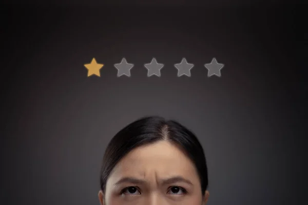 Asyalı mutsuz kadın ve yıldız ikonu hologram efektinin yakın çekimi.