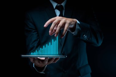 Tablet planlaması kullanan işadamı, grafik hologram efektli dijital pazarlama kullanıyor.