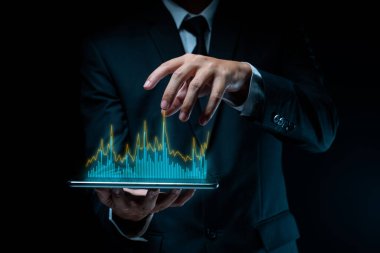 Tablet planlaması kullanan işadamı, grafik hologram efektli dijital pazarlama kullanıyor.