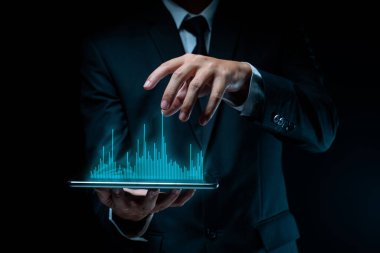 Tablet planlaması kullanan işadamı, grafik hologram efektli dijital pazarlama kullanıyor.