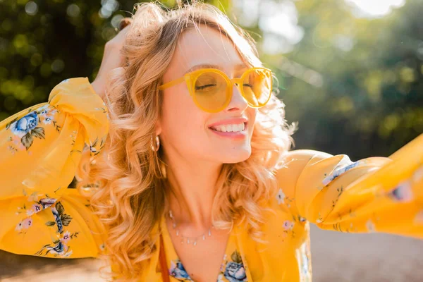 自撮り写真を作るサングラスを身に着けている黄色のブラウスで美しいブロンドのスタイリッシュな笑顔の女性の肖像画 カラフルな秋のファッショントレンド 明るい晴れた日 肯定的な幸せな気分 — ストック写真