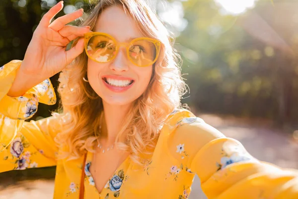 自撮り写真を作るサングラスを身に着けている黄色のブラウスで美しいブロンドのスタイリッシュな笑顔の女性の肖像画 カラフルな秋のファッショントレンド 明るい晴れた日 肯定的な幸せな気分 — ストック写真