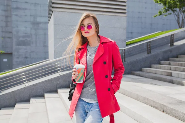 분홍색 코트를 길거리에서 청바지를 커피를 마시며 헤드폰으로 음악을 스타일의 선글라스를 — 스톡 사진