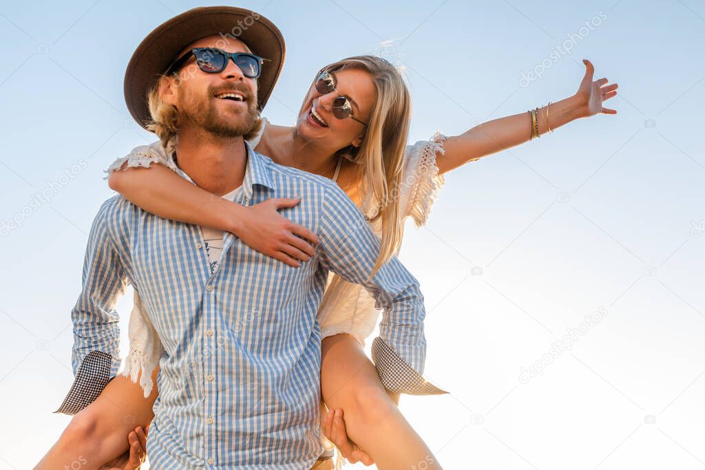 attractive happy couple laughing traveling in summer by sea, man and woman wearing sunglasses, boho hipster style fashion having fun together