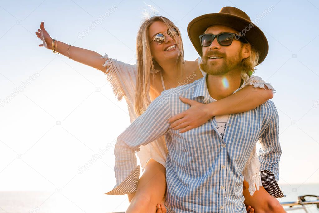 attractive happy couple laughing traveling in summer by sea, man and woman wearing sunglasses, boho hipster style fashion having fun together