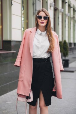 seksi genç stil güzel kadın sokakta yürüyor, pembe ceket, çanta, güneş gözlüğü, beyaz gömlek, siyah etek, moda kıyafeti, sonbahar modası, gülen mutlu aksesuarlar,