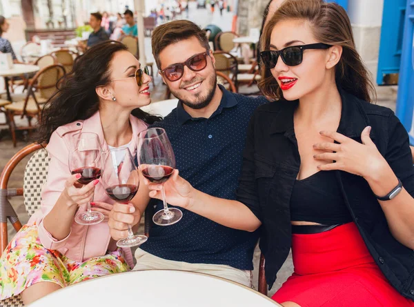 young hipster company of friends sitting in city street cafe, holding glasses, toasting, celebrating, drinking wine, sunglasses, summer vacation, party, having fun, smiling, happy, positive