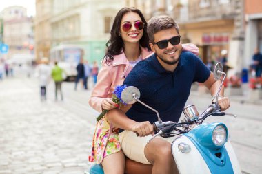 Genç, güzel, hippi bir çift motosikletle şehir caddesinde, yaz tatilinde, seyahat ederken, romantizm yaparken, gülümserken, mutluyken, eğlenirken, güneş gözlüğü takarken, şık giyinirken, aşkta, maceralarda, randevuda...