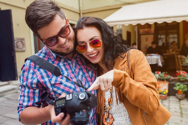 young man and woman in love traveling around europe, summer vacation, honey moon, having fun, suglasses, vintage style, smiling happy, embracing, photo camera