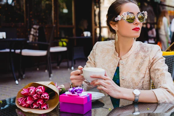 Νέα Κομψή Γυναίκα Γυαλιά Ηλίου Μόδας Κάθεται Στο Καφέ Κρατώντας — Φωτογραφία Αρχείου