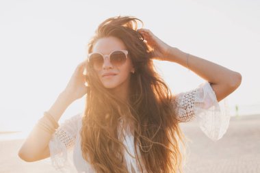 Genç, ince, güzel bir kadın gün batımı kumsalında, neşeli, dans, koşu, bohem kıyafeti, indie tarzı, yaz tatili, güneşli, eğleniyor, pozitif ruh hali, romantik, su sıçratan, siluet, mutlu.