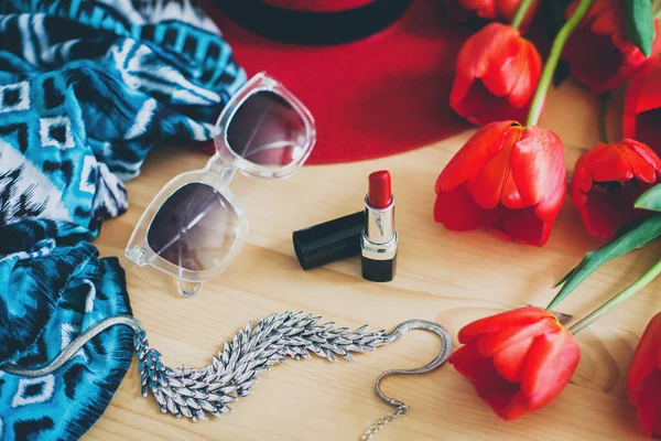 woman\'s accessories, red tulips, sunglasses, hat, lipstick, scarf, necklace, spring fashion trend, still life, view from above, details, vintage bohemian style,