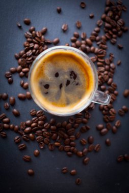 Kahve fincanı taze demlendi kahve ve kahverengi kavrulmuş kahve çekirdekleri ile