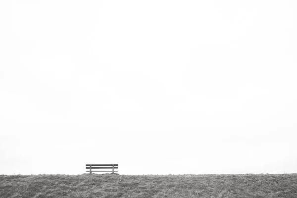 Un único banco de madera vacío en el horizonte — Foto de Stock