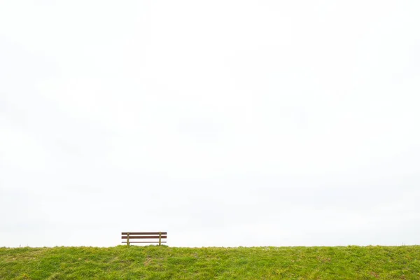 Un único banco de madera vacío en el horizonte — Foto de Stock