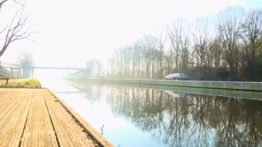 Kanal veya nehir su üzerinde Puslu güneşli gündoğumu veya günbatımı, nehir kenarında alınan Timelapse