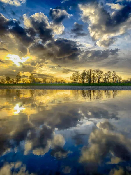 Ciel nuageux dans un paysage rural reflété dans une flaque d'eau — Photo