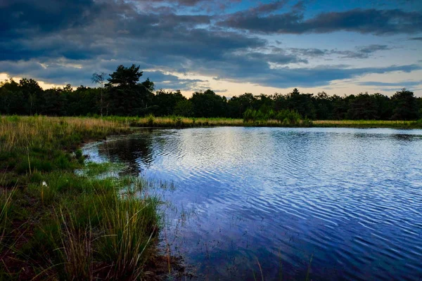 Dramatischer Sonnenuntergang, der sich im Wasser spiegelt — Stockfoto