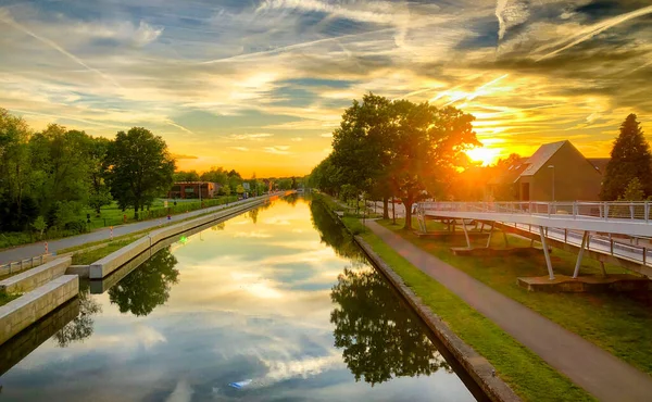 Coucher de soleil spectaculaire sur un plan d'eau entouré d'arbres — Photo