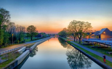Dramatik ve büyüleyici rengarenk günbatımı gökyüzü bir kanal üzerinde