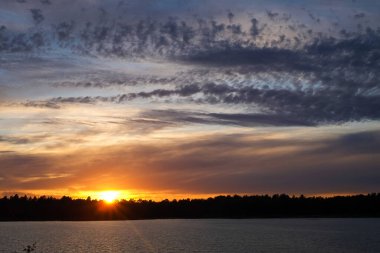 Orman gölünün üzerinde dramatik bir gün batımı