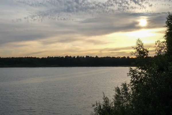 Pôr-do-sol dramático sobre um lago florestal — Fotografia de Stock
