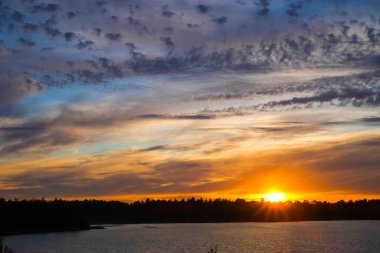 Orman gölünün üzerinde dramatik bir gün batımı