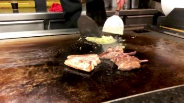 Japon aşçı Teppanyaki pişiriyor. 
