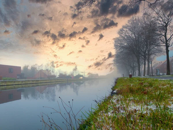 Coucher de soleil spectaculaire sur un plan d'eau entouré d'arbres — Photo