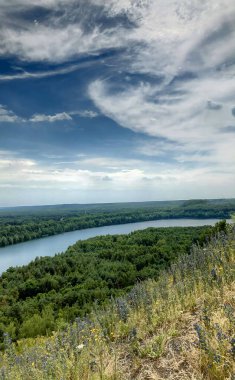 Bir yamacın yakınında bir su kütlesinin yanında.