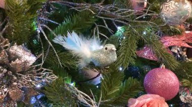 Geceleri parıldayan ışıklarla bir Noel ağacının yakınında.