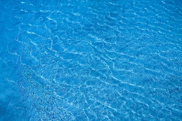 Blue waves texture. Blue marine background. Transparent sea water and bottom.