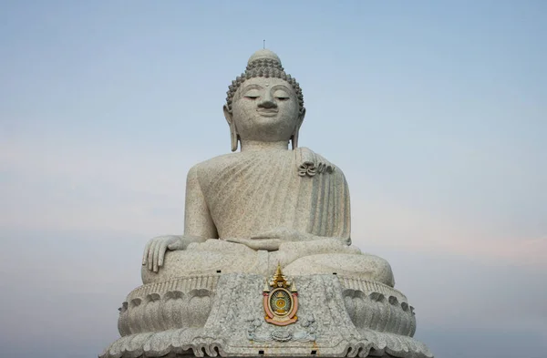 Big Buddha sculpture. Beautiful religious sculpture from white marble on a light sky background.