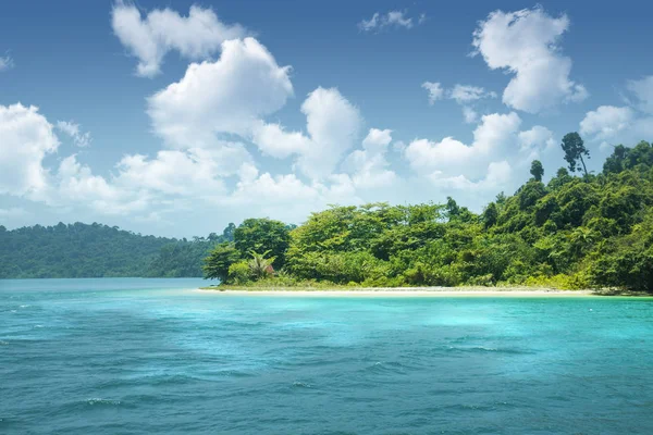 Beautiful paradise green island in the ocean. Tropics. Thailand Andaman Sea. Seascape with azure water and an island with many plants.