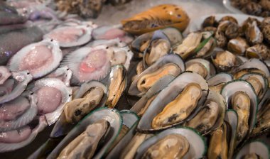 Taze midyeler ve buz üzerinde deniz tarağı. Açık istiridye deniz ürünleri pazarı, deniz ürünleri lezzetleri. Sokak yemekleri.
