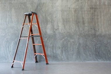 Çıplak çimento duvarda turuncu demir merdiven 