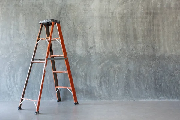 orange iron ladder  on Bare cement wall